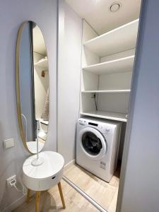 a bathroom with a washing machine and a mirror at Kora Apartments in Prague