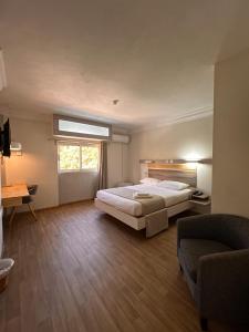 a bedroom with a bed and a couch and a window at Le Saint Georges Hotel in Port Louis +23 photos