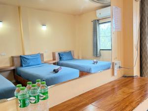 a room with two beds with water bottles on the floor at Ocean View Resort in Ko Tao