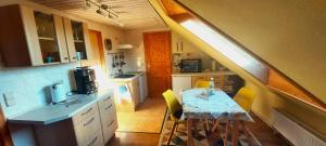 a kitchen with a table and yellow chairs in it at Ferienwohnung Lucke in Luftkurort Lückendorf