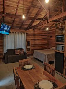 a living room with a couch and a bed and a table at Chalé Céu Estrelado in Paraisópolis