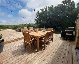 a wooden table and chairs on a wooden deck at Gîte grand confort 15 personnes - Le Domaine - Wimereux in Wimereux