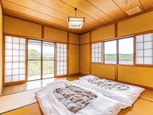 a bedroom with two beds in a room with windows at The M HONMACHI in Nakatsugawa