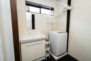 a white bathroom with a sink and a window at 三十三Kumo in Kyoto +23 photos