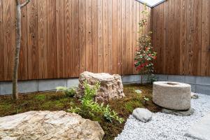 a garden with a fence and a tree and rocks at 三十三Kumo in Kyoto
