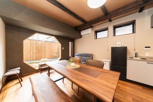 a living room with a table and a kitchen at 三十三Kumo in Kyoto
