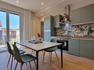 a kitchen with a dining room table and chairs at Dolce 2 bedrooms Apartment Milano 2mins to Rho Fiera & 25mins to Duomo Centre & 100m to Metro in Pero