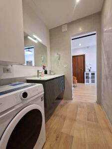 a kitchen with a washer and a sink and a stove at Dolce 2 bedrooms Apartment Milano 2mins to Rho Fiera & 25mins to Duomo Centre & 100m to Metro in Pero