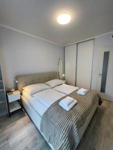 a bedroom with a large bed with two towels on it at Kora Apartments in Prague