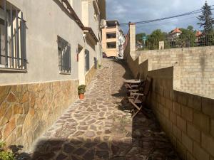 a stone alley between two buildings next to a wall at Clau al castell apartament in Serra