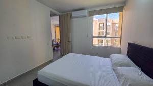 a bedroom with a white bed and a window at Capriella, Serena Del Mar in Cartagena de Indias +12 photos