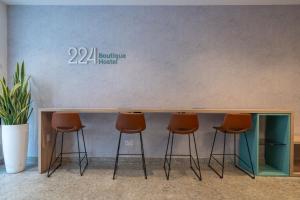 a counter with four stools in front of a wall at 224 Boutique Hostel in Sliema