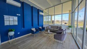 a lobby with blue walls and a couch and chairs at Capriella, Serena Del Mar in Cartagena de Indias