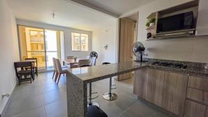 a kitchen with a counter top and a living room at Capriella, Serena Del Mar in Cartagena de Indias