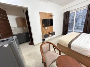 a hotel room with a bed and a tv at The Grand Hotel Akshay in Gurgaon