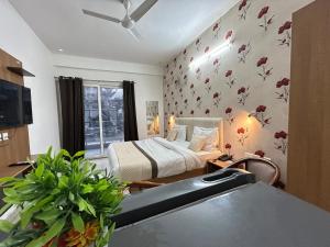 a bedroom with a bed with flowers on the wall at The Grand Hotel Akshay in Gurgaon +46 photos