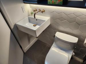 a bathroom with a white toilet and a sink at Charming 2BR Cottage with Bay and City Views-Gated Luxury Private Place in San Francisco +14 photos