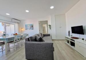 a living room with a couch and a table and a television at Blue Sun Armação in Armação de Pêra