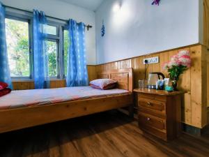 a bedroom with a wooden bed and a wooden dresser at Petratos Homestay in Kalimpong +26 photos