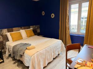 a bedroom with a bed with a blue wall at Hotel Comédie - Place De La Comédie Opéra in Montpellier