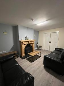 a living room with a couch and a fireplace at Carriegart in Lurgan