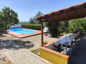 a backyard with a swimming pool and a table and chairs at Costas Guests in Sardoal