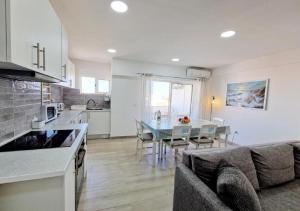 a kitchen and living room with a couch and a table at Blue Sun Armação in Armação de Pêra