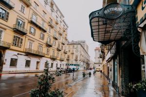 a city street with buildings on a rainy day at Hotel Astoria in Turin +22 photos
