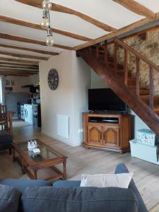 a living room with a couch and a tv at Sharecroppers Cottage with Swimming Pool in Pagéas