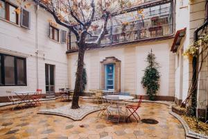 a courtyard with tables and chairs and a tree at Hotel Astoria in Turin