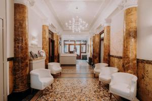 a corridor with a waiting room with white chairs at Hotel Astoria in Turin