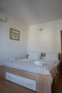 a bed in a room with a white wall at Apartmani Roić in Gradac