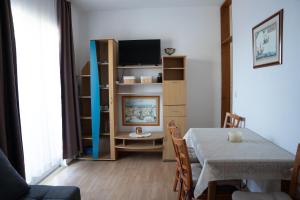 a living room with a table and a tv at Apartmani Roić in Gradac