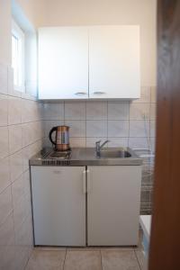 a kitchen with white cabinets and a sink at Apartmani Roić in Gradac +21 photos