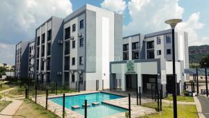 a building with a swimming pool in front of it at Suite 303 in Gaborone