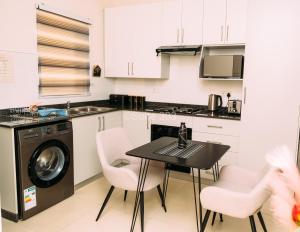 a kitchen with a table and a washing machine at Suite 303 in Gaborone