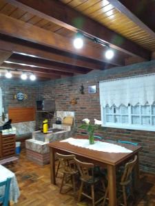 a kitchen with a wooden table and a brick wall at Cabana da Serra in Riozinho