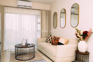 a living room with a couch and a table and mirrors at Suite 303 in Gaborone +16 photos