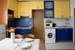a kitchen with blue cabinets and a washing machine at Apartmani Roić in Gradac