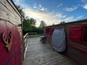 a deck with a hammock on the side of a house at La Verdine Lodge & Spa in Romorantin