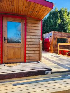 a wooden cabin with a door and a playground at La Verdine Lodge & Spa in Romorantin +8 photos