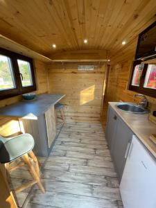 a kitchen in a tiny house with a sink at La Verdine Lodge & Spa in Romorantin
