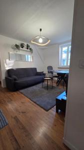 a living room with a couch and a table at Calme et confort au cœur du vieux Troyes in Troyes