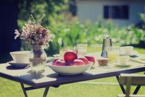 a table with a bowl of fruit and a vase of flowers at Moncervin in Saint Vincent