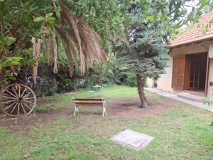 a park bench sitting under a tree next to a building at Emmac Zen in Ciudad Lujan de Cuyo