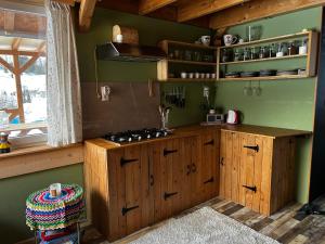 a kitchen with wooden cabinets and a stove at Tiny House at Sedliacky Dvor - Brezno in Brezno