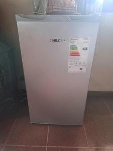a white refrigerator is sitting on a tile floor at Emmac Zen in Ciudad Lujan de Cuyo