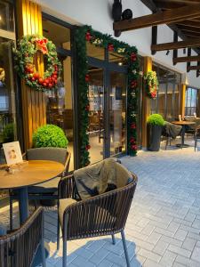 a patio with tables and chairs and christmas decorations at Apart-Hotel Bela Reka in Brzeće