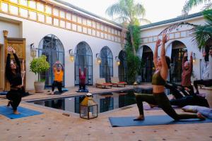 a group of people doing yoga by a pool at Daba Village in Marrakesh