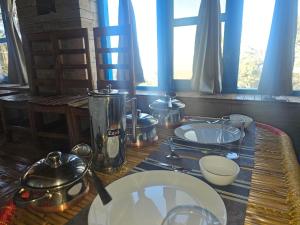 a table with plates and utensils on top at Nandi Roop Homestay in Panuānaula +25 photos